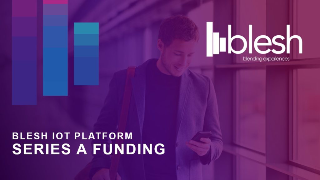 A pitch deck cover slide with a man wearing a suit jacket is smiling while looking at his phone in an indoor setting. To his right, text reads "BLESH IoT PLATFORM SERIES A FUNDING" beneath the Blesh logo, which features purple and blue vertical bars next to the word "blesh" and the tagline "blending experiences with innovation.